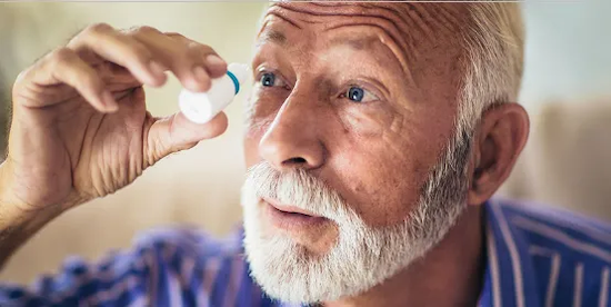 A man with dry eye putting in eyedrops